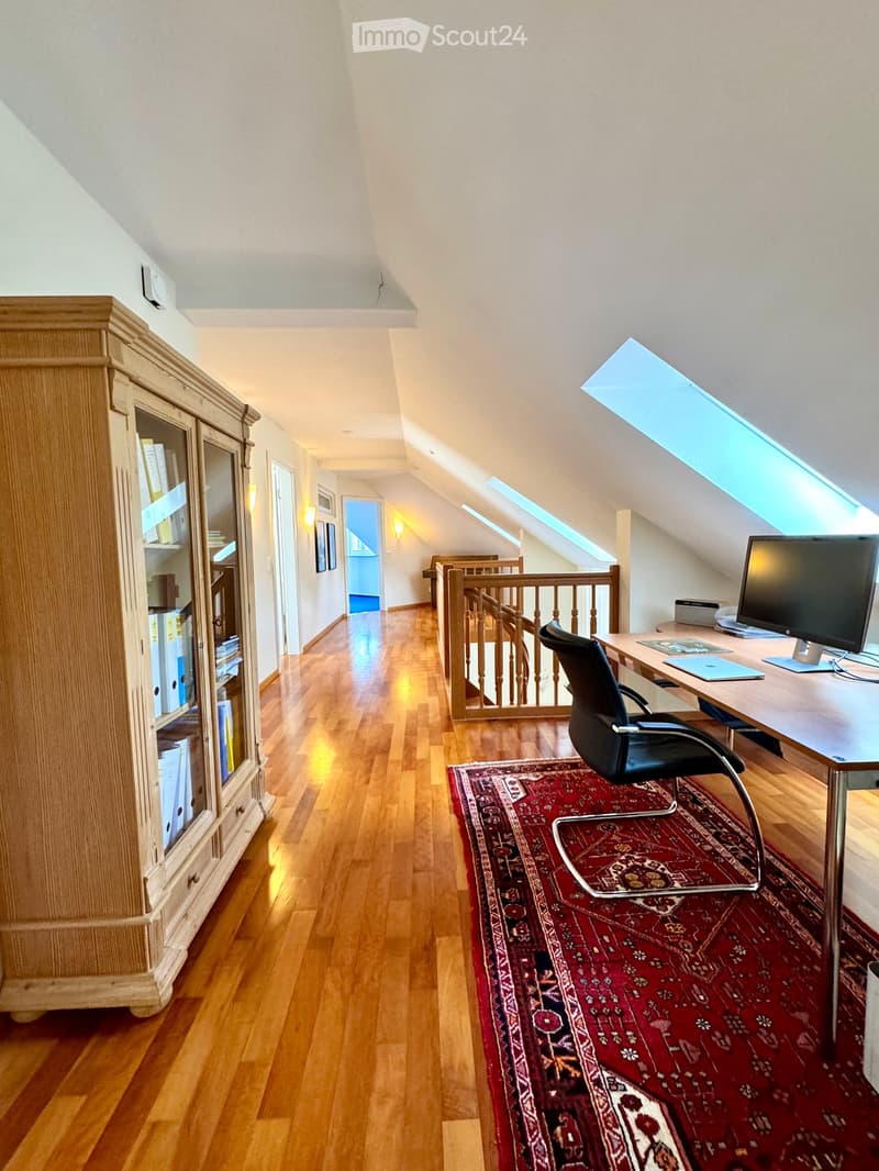 office area, hardwood floor, office desk with monitor, office chair, wooden shelf with books, wooden cabinet with glass doors, carpet