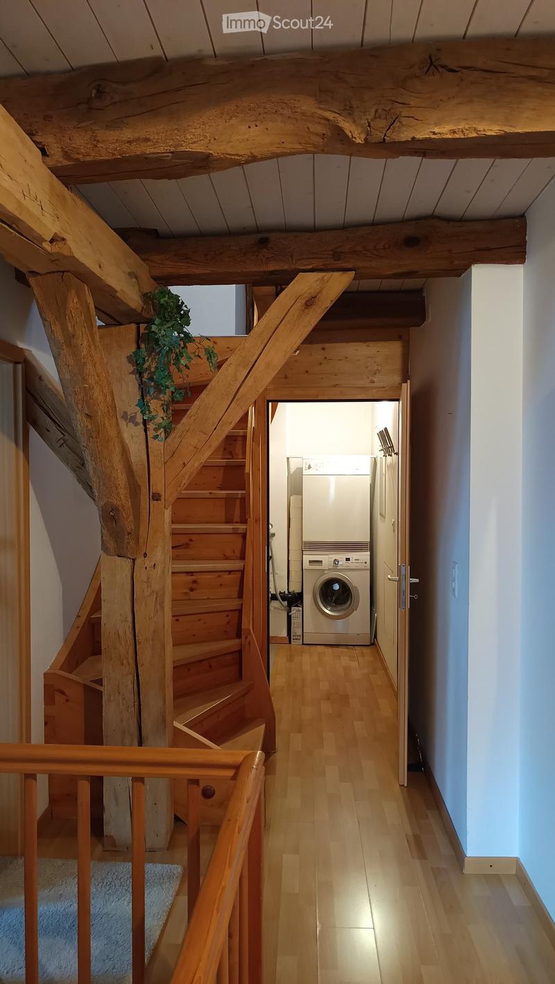 entry hallway, wooden stairs, white washing machine, wooden beams