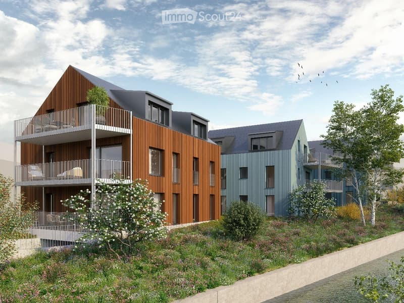 Modern multi-story residential building with wooden and blue facades, balconies, and surrounding greenery.