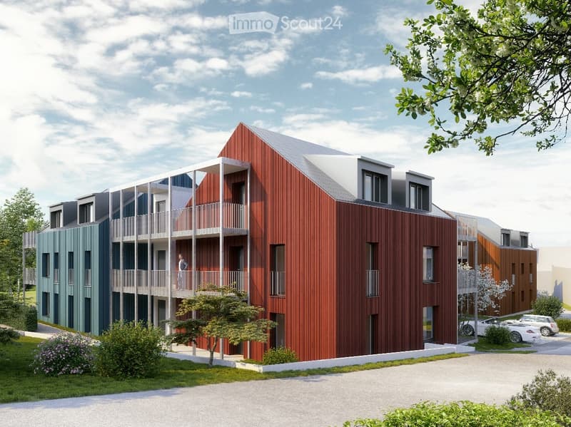 Modern multi-story residential building with a mix of red and blue facades, balconies, and a parking area.