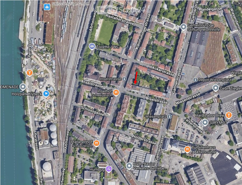 Aerial view of an urban area showing streets, buildings, and landmarks including a train station, a river, and various labeled locations.