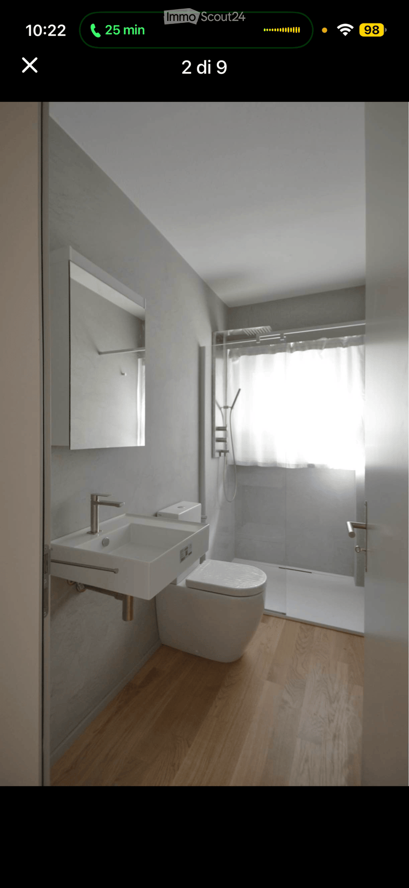 Modern bathroom with a double sink, toilet, glass shower enclosure, and a mirror cabinet.