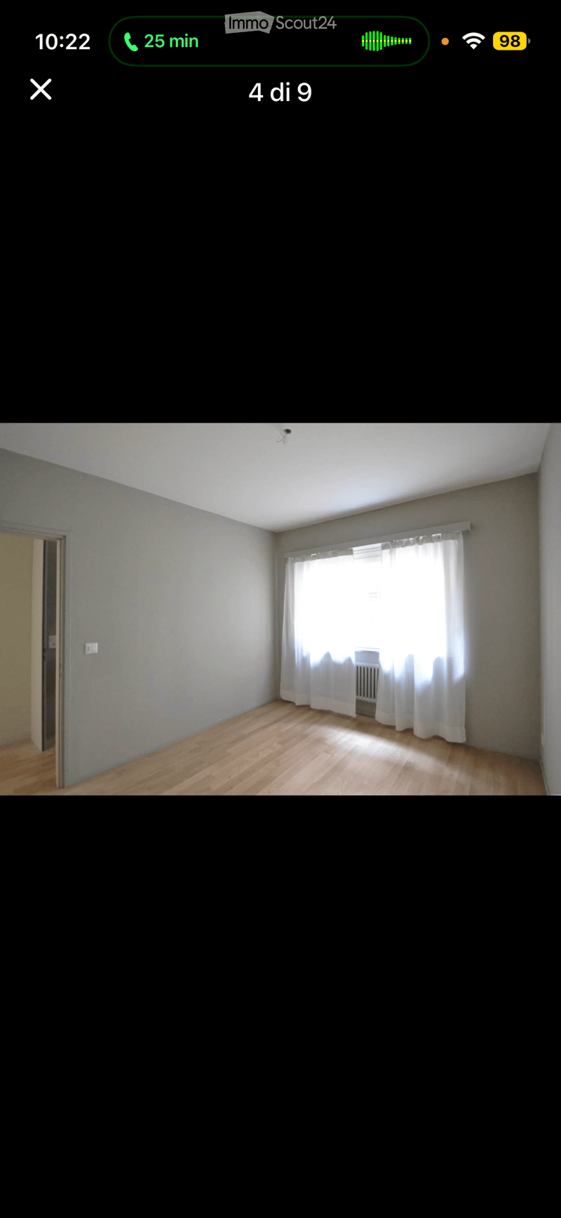 Empty room with wooden flooring, white walls, and a window with white curtains. No furniture or equipment is present.