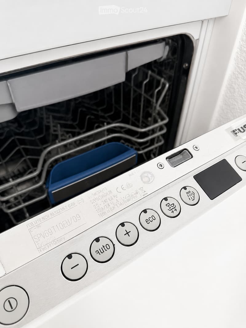 Close-up of a modern stainless steel dishwasher with control panel featuring various buttons and settings.