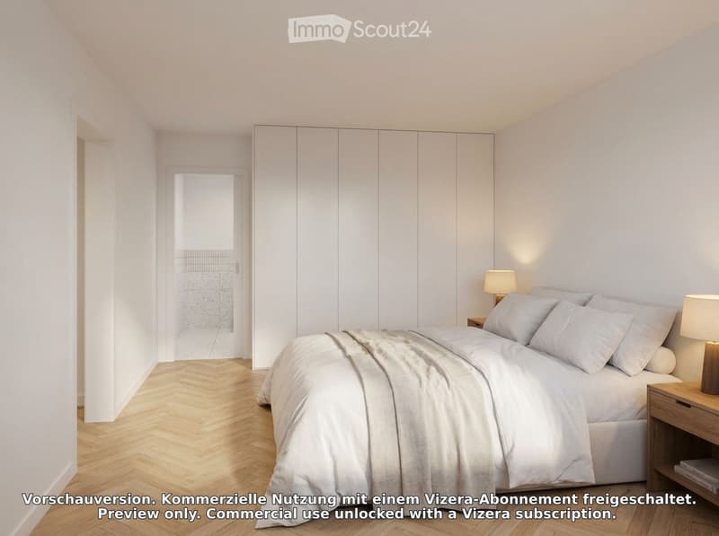 Modern bedroom with a large bed, white bedding, nightstands, lamps, and a large white wardrobe.