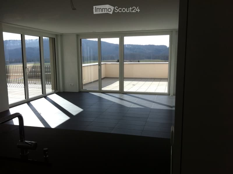 Empty room with large sliding glass doors leading to a balcony, tiled floor, and natural light from the windows.
