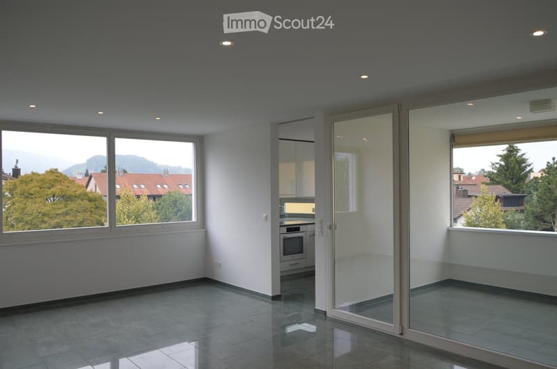 Empty room with large windows, tiled floor, and modern ceiling lights. No furniture or equipment present.