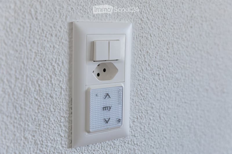 A modern electrical outlet with two switches and a USB port, mounted on a textured white wall.