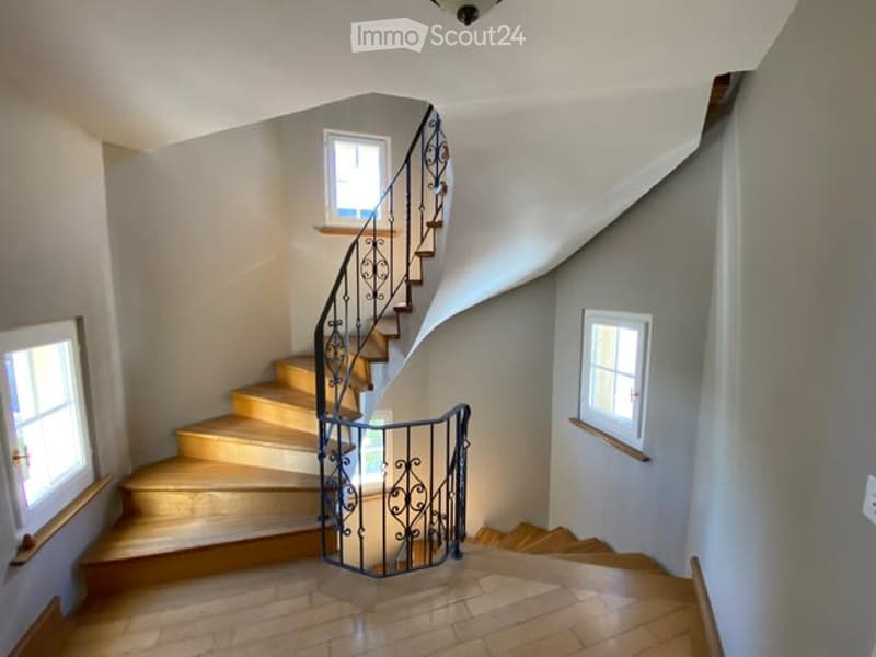 wooden staircase, wrought iron railing, tiled floor, white walls, windows