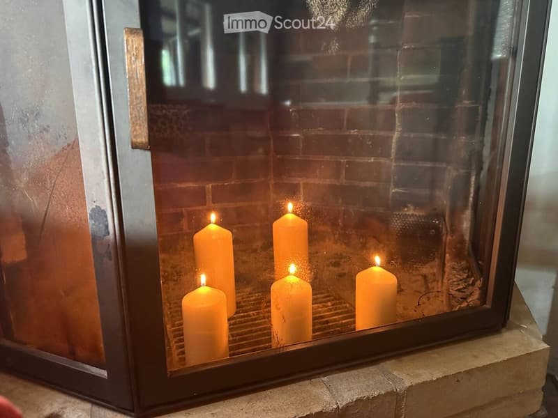 {"type": "Fireplace", "objects": ["candles"], "description": "A fireplace with four lit orange candles placed inside, reflecting a warm glow on the brick wall behind them.", "localized_descriptions": {"EN": "A fireplace with four lit orange candles placed