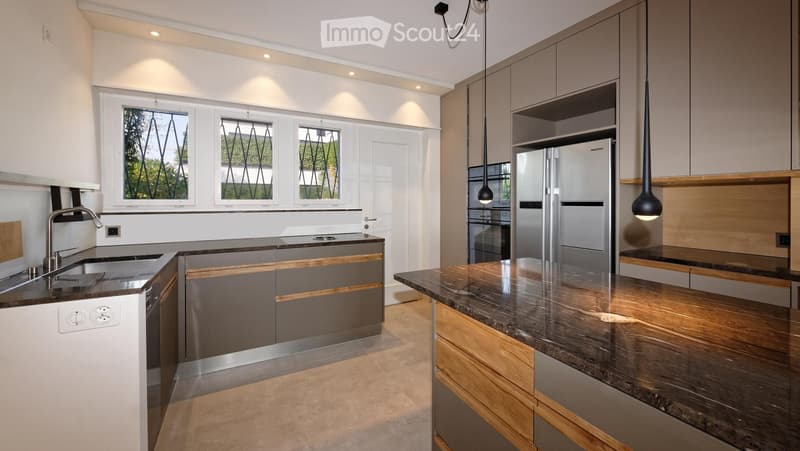 Modern kitchen with stainless steel appliances, granite countertops, and pendant lighting.