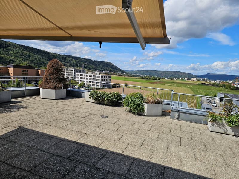 Roof terrace with gravel flooring, metal railing, potted plants, and a scenic view of a valley and hills.