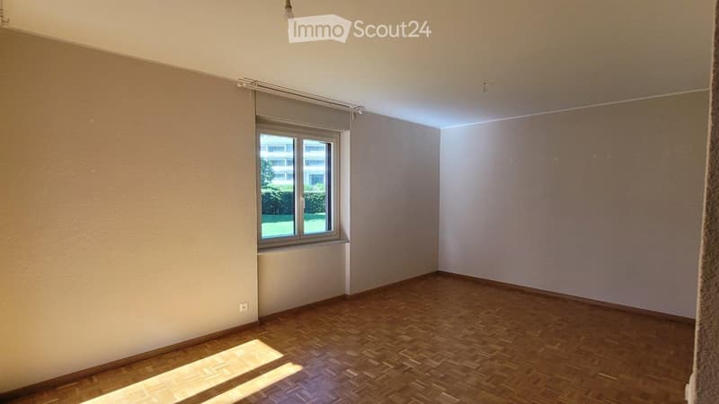 Empty room with wooden flooring, white walls, and a single window with blinds. No furniture or equipment present.