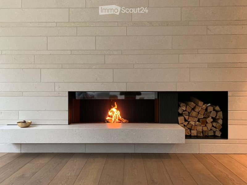 white brick wall, fireplace with fire, pile of wood, bowl