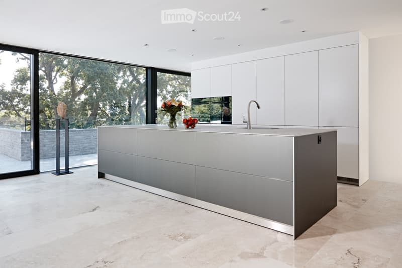 modern kitchen with island, floor-to-ceiling windows, marble countertops, stainless steel appliances, and ample natural light