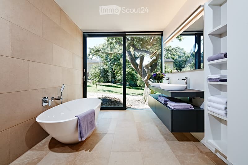 Modern bathroom with large windows, walk-in bathtub, double vanity, and open shelving