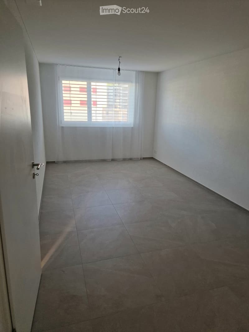 Empty room with tiled floor, white walls, and a window with blinds. No furniture or equipment present.