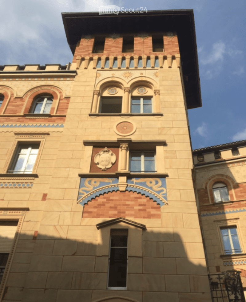 A multi-story building with ornate architectural details, including decorative moldings, arched windows, and intricate patterns on the facade.