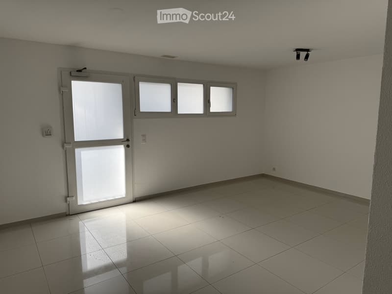 Empty room with tiled floor, white walls, and a door with glass panels. No furniture or equipment is present.