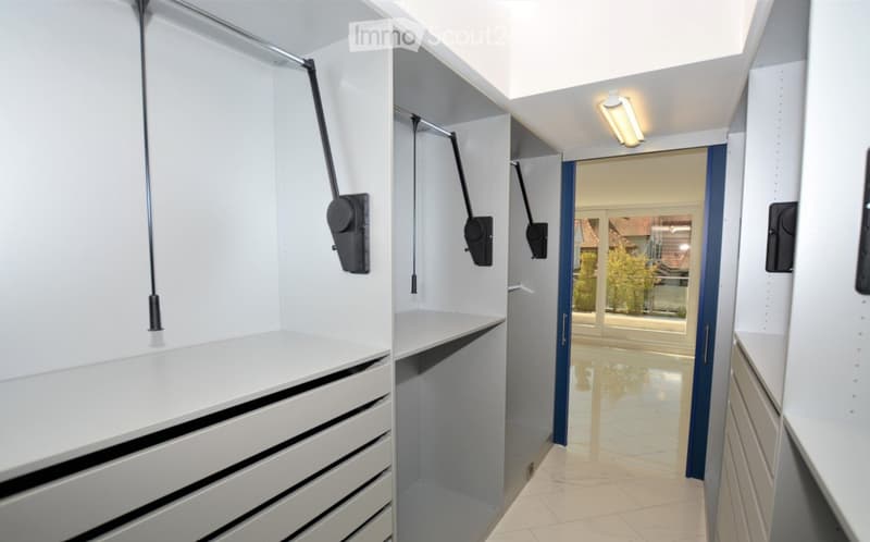 Modern, well-lit hallway with built-in storage units and a sliding door leading to an outdoor area.