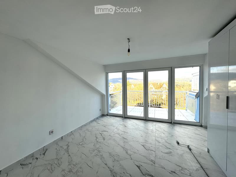 Empty room with white walls, marble flooring, and large sliding glass doors leading to a balcony.