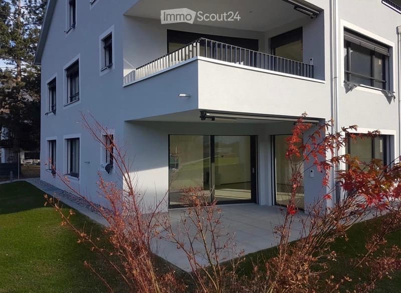 Modern two-story house with white exterior, large windows, and a balcony on the upper level.