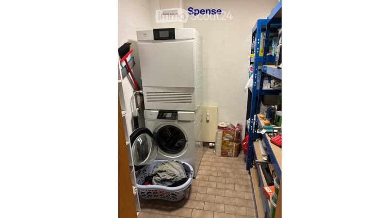 Laundry room with a washing machine, dryer, shelf, and laundry basket.