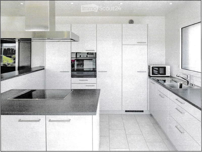 Modern kitchen with white cabinets, stainless steel appliances, and a central island.
