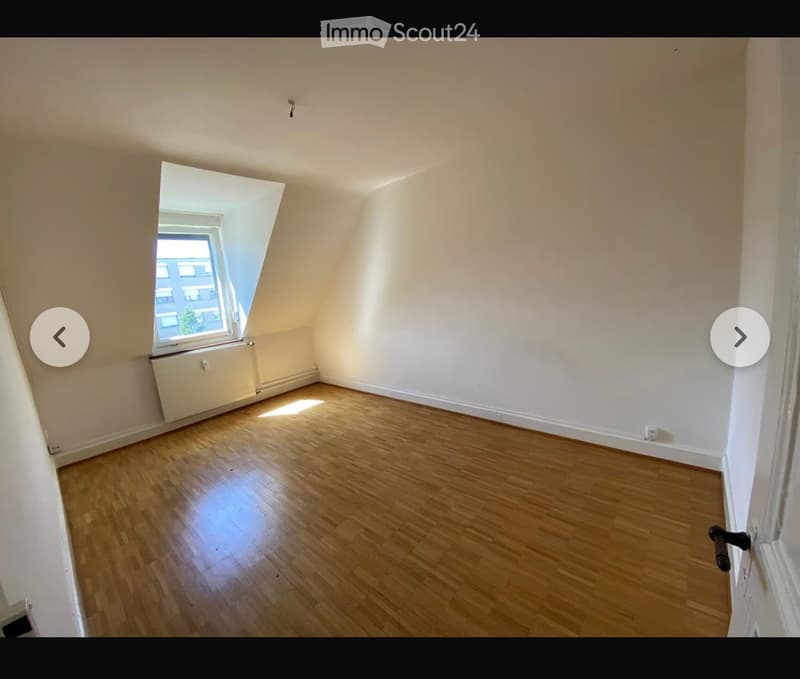 Empty room with wooden flooring, white walls, and a large window letting in natural light. No furniture or equipment is present.