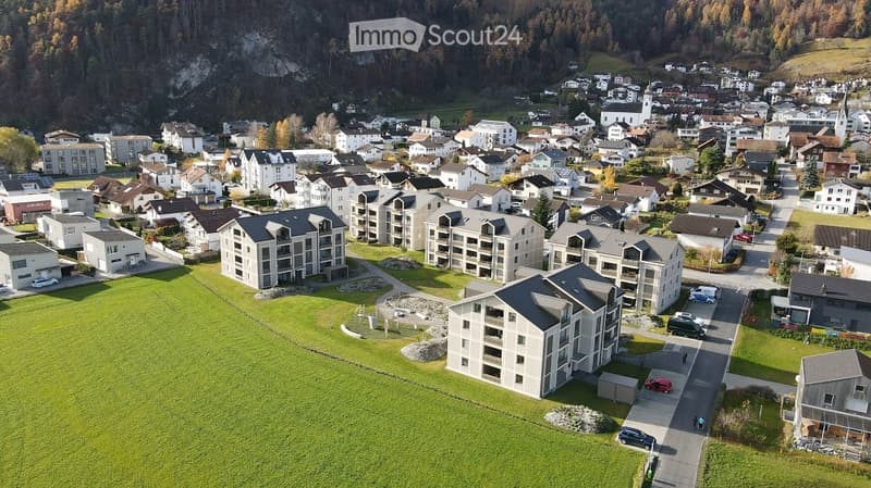 Aerial view of a residential area with multiple apartment buildings, houses, and green spaces.