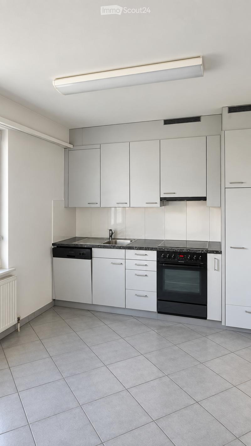 Modern kitchen with white cabinets, stainless steel appliances, and a black countertop.