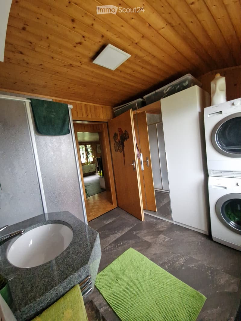 Bathroom with a sink, faucet, towel, and a washing machine in the corner.