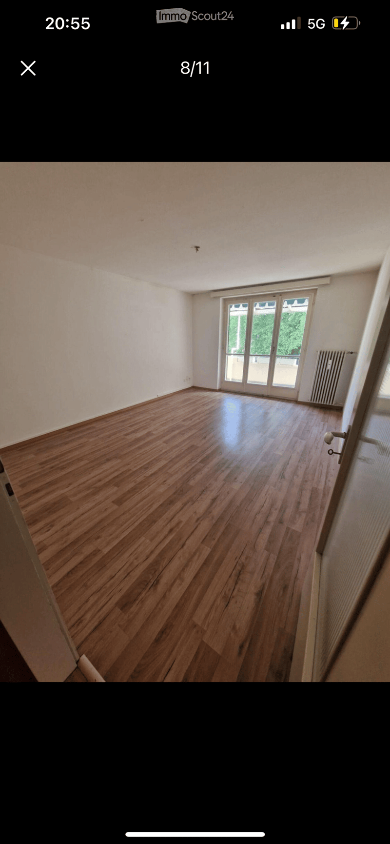 room with large balcony, hardwood floors, sliding glass door leading to balcony