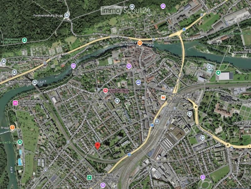 A detailed map of a city area showing streets, buildings, and landmarks. The map includes various points of interest marked with icons, a river running through the area, and a dense network of roads.
