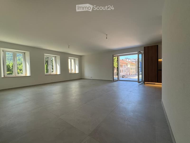 Empty room with tiled floor, large windows, and an open sliding door leading to a balcony.