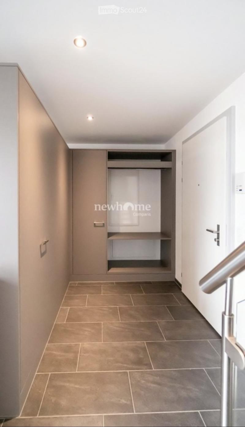 Modern hallway with tiled floor, built-in storage unit, and recessed lighting.