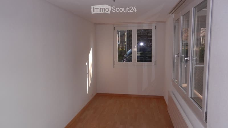 empty room, wooden floor, white walls, windows, radiator