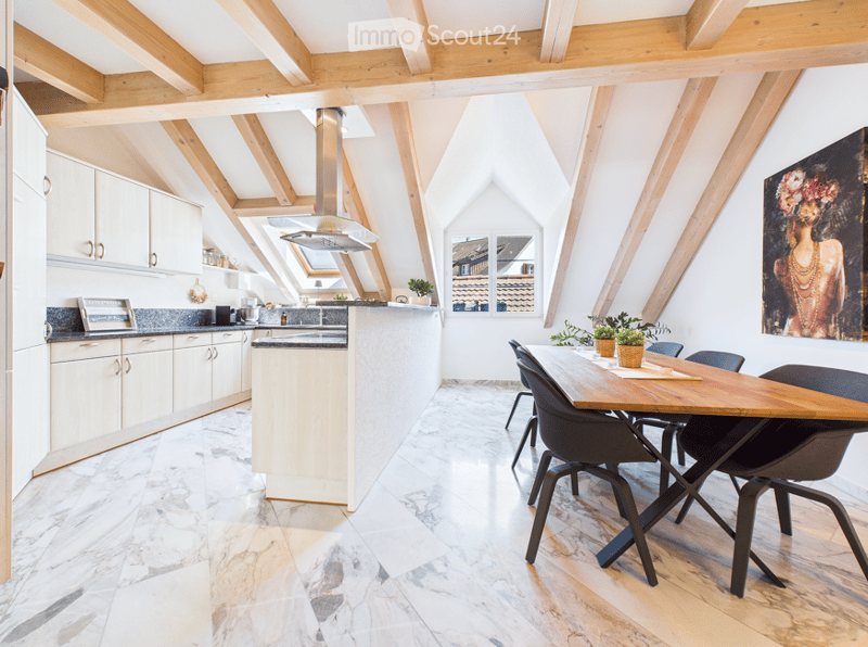 Bright, airy kitchen and dining area with exposed wooden beams, marble flooring, modern cabinets, and a large dining table with chairs.