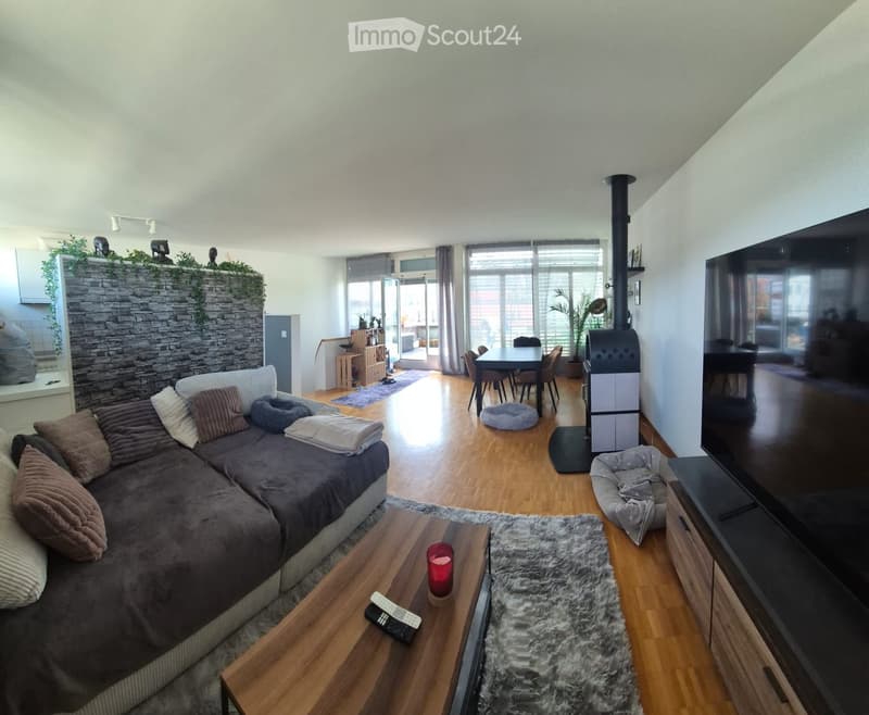 Living room with a sectional sofa, coffee table, fireplace, dining area, and TV stand.