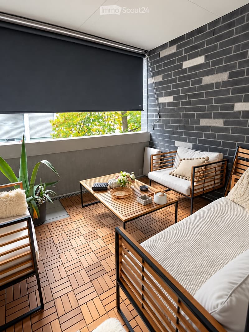 Modern rooftop terrace with wooden decking, white seating, coffee table, and decorative items.