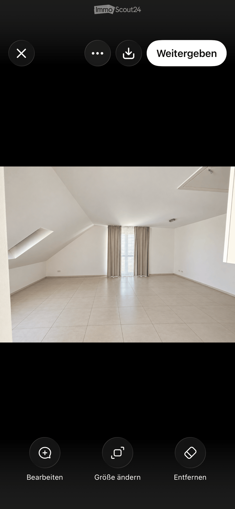 Empty room with white walls, tiled floor, and large windows with curtains. No furniture or equipment present.