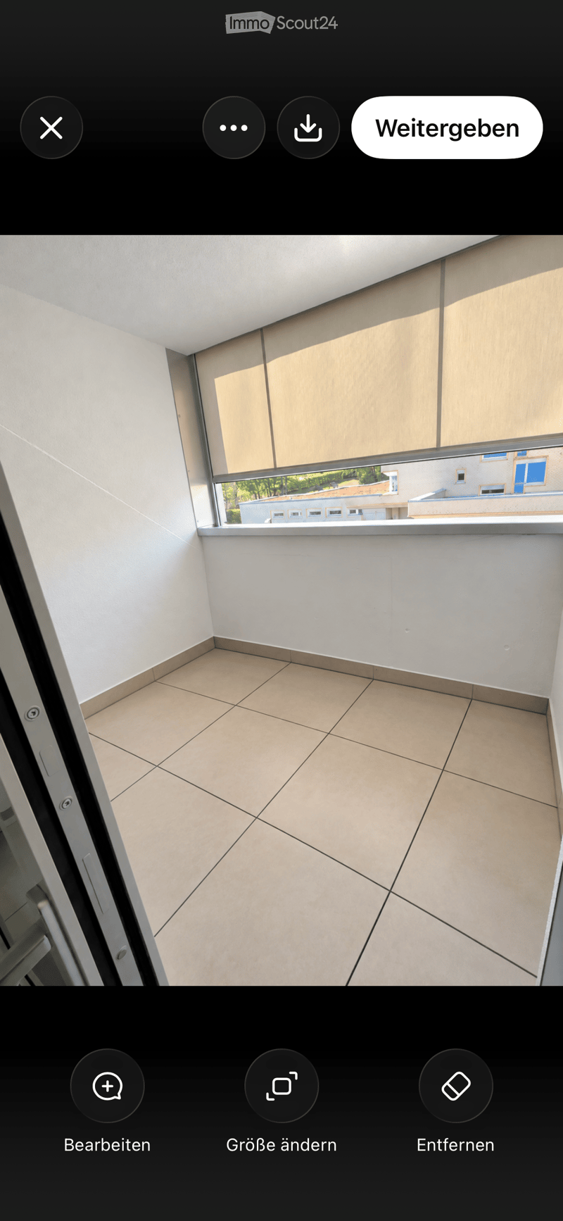 Empty room with tiled floor and large window offering a view of the outside. No furniture or equipment present.