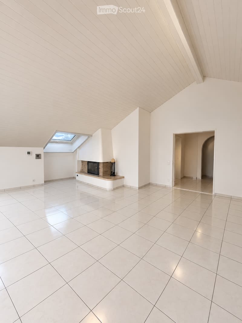 Empty room with white tiled floor, white walls, and a built-in fireplace with a small skylight above.