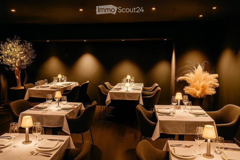 Elegant restaurant interior with multiple dining tables set with plates, wine glasses, cutlery, and napkins, surrounded by chairs and decorative lamps. The space features warm lighting and a sophisticated ambiance.