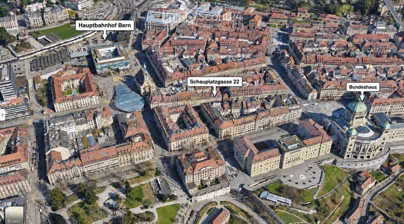 Aerial view of a dense urban area with numerous buildings, labeled landmarks including Hauptbahnhof Bern, Schauplatzgasse 22, and Bundeshaus, surrounded by streets and green spaces.