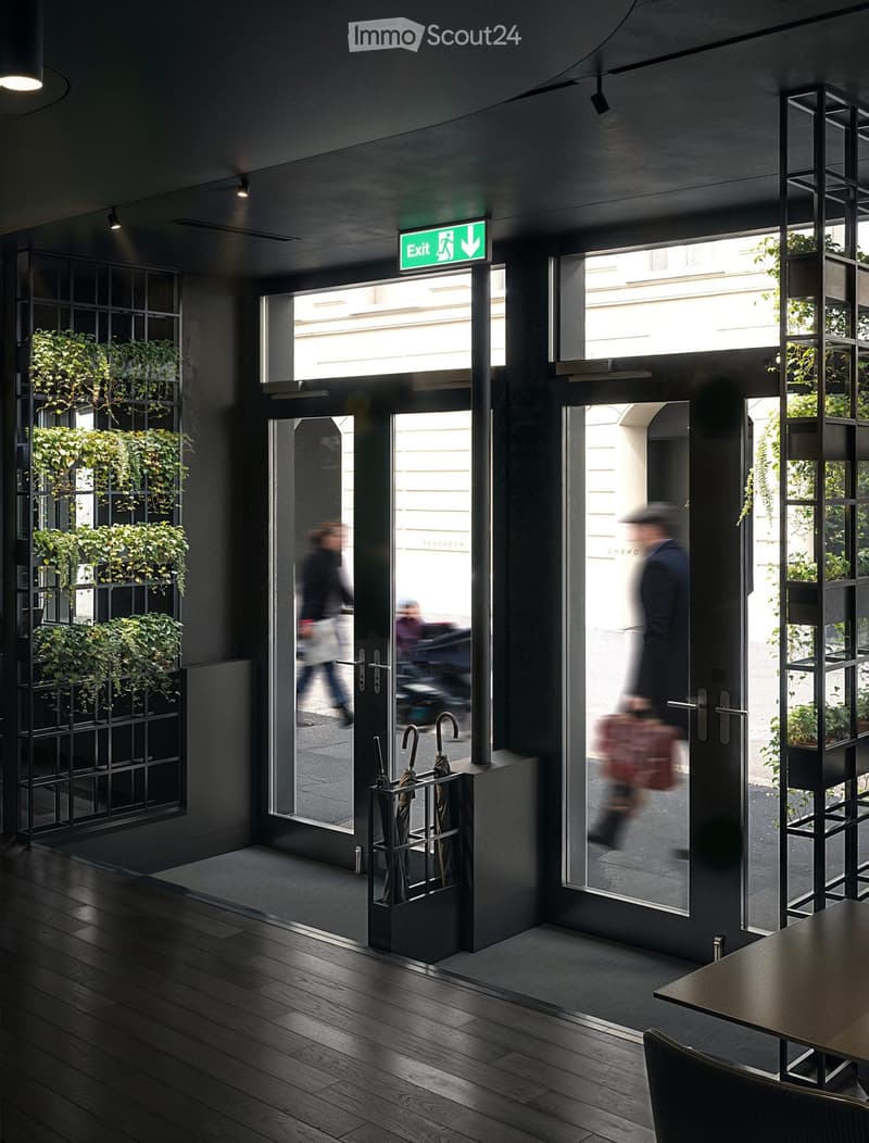 Modern hallway with dark wooden flooring, glass doors leading outside, umbrella stand, and greenery in planters on the walls.