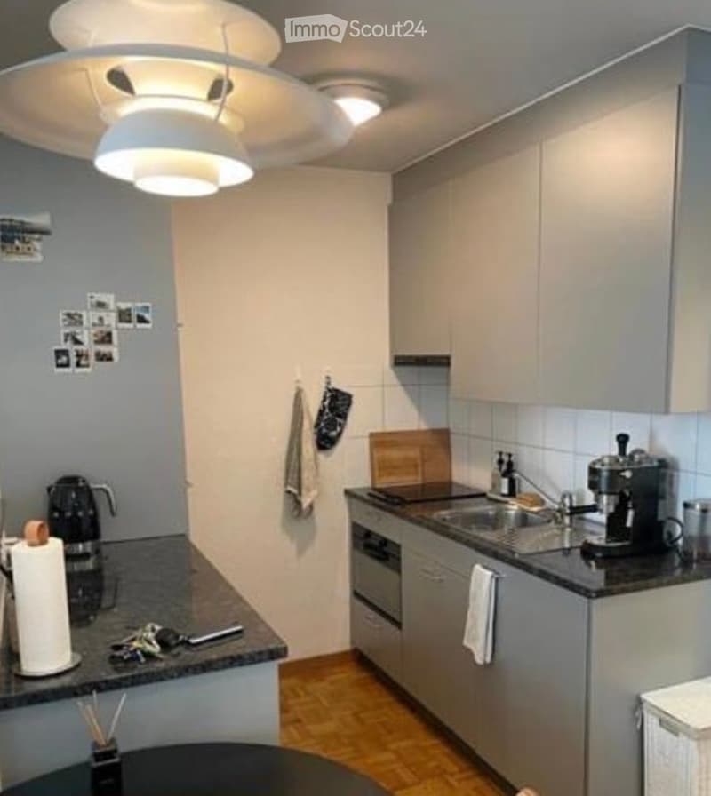 Modern kitchen with stainless steel appliances, granite countertops, and light wood flooring. Features include a coffee maker, sink, oven, and cabinets.