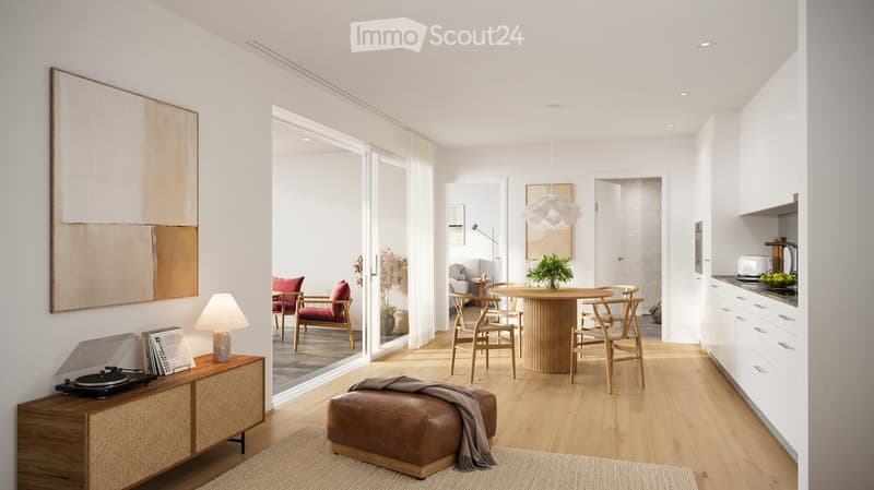 Modern living and dining area with light wood flooring, white walls, and large windows. Features a sofa, dining table with chairs, a leather stool, a lamp, a cabinet with a turntable, and a kitchen area with white cabinets and a counter.