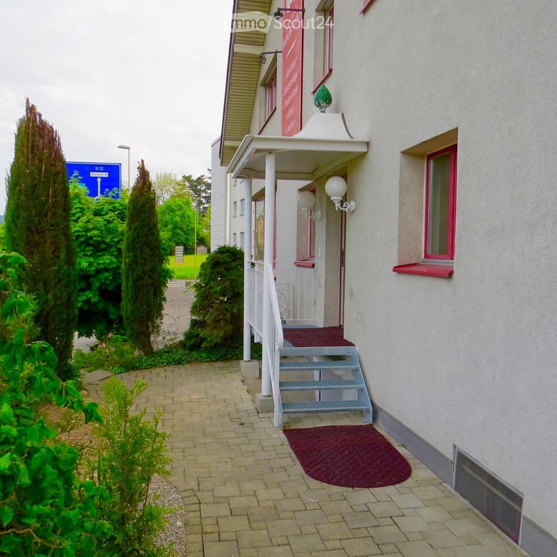 white building, red trim, red carpet, white railing, lamp