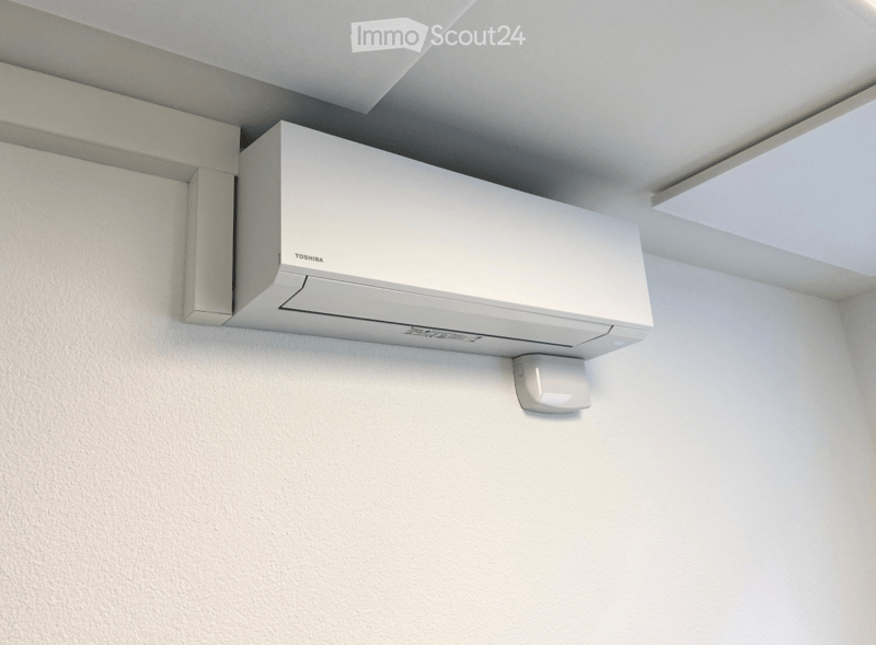 A white Toshiba air conditioner unit mounted on a white wall with a sleek, modern design.